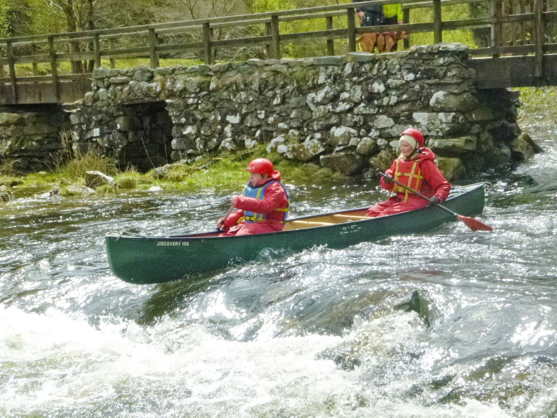 2 adults in a canoe on white water